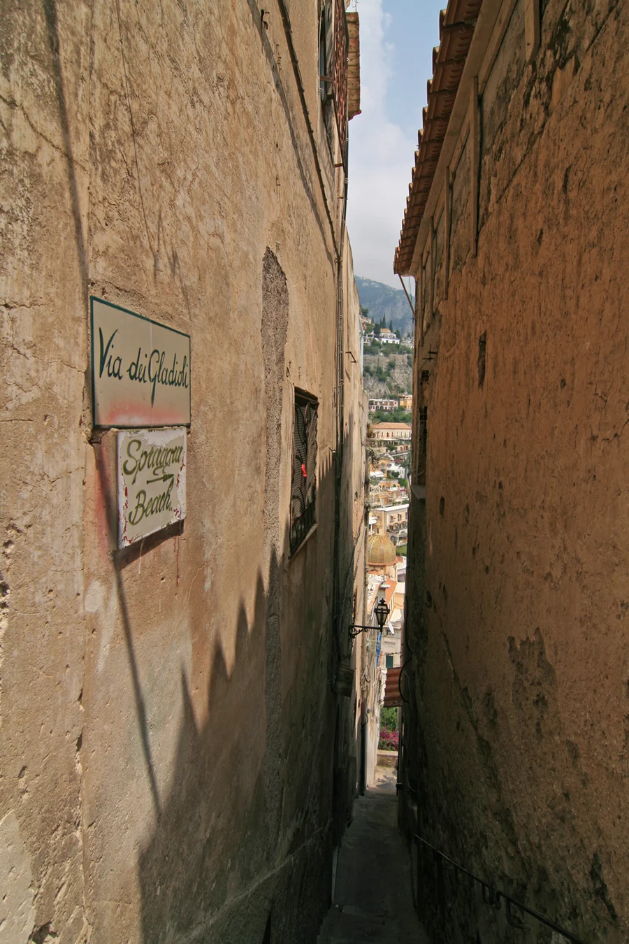 Steep pedestrian street and steps in Positano lined with buildings