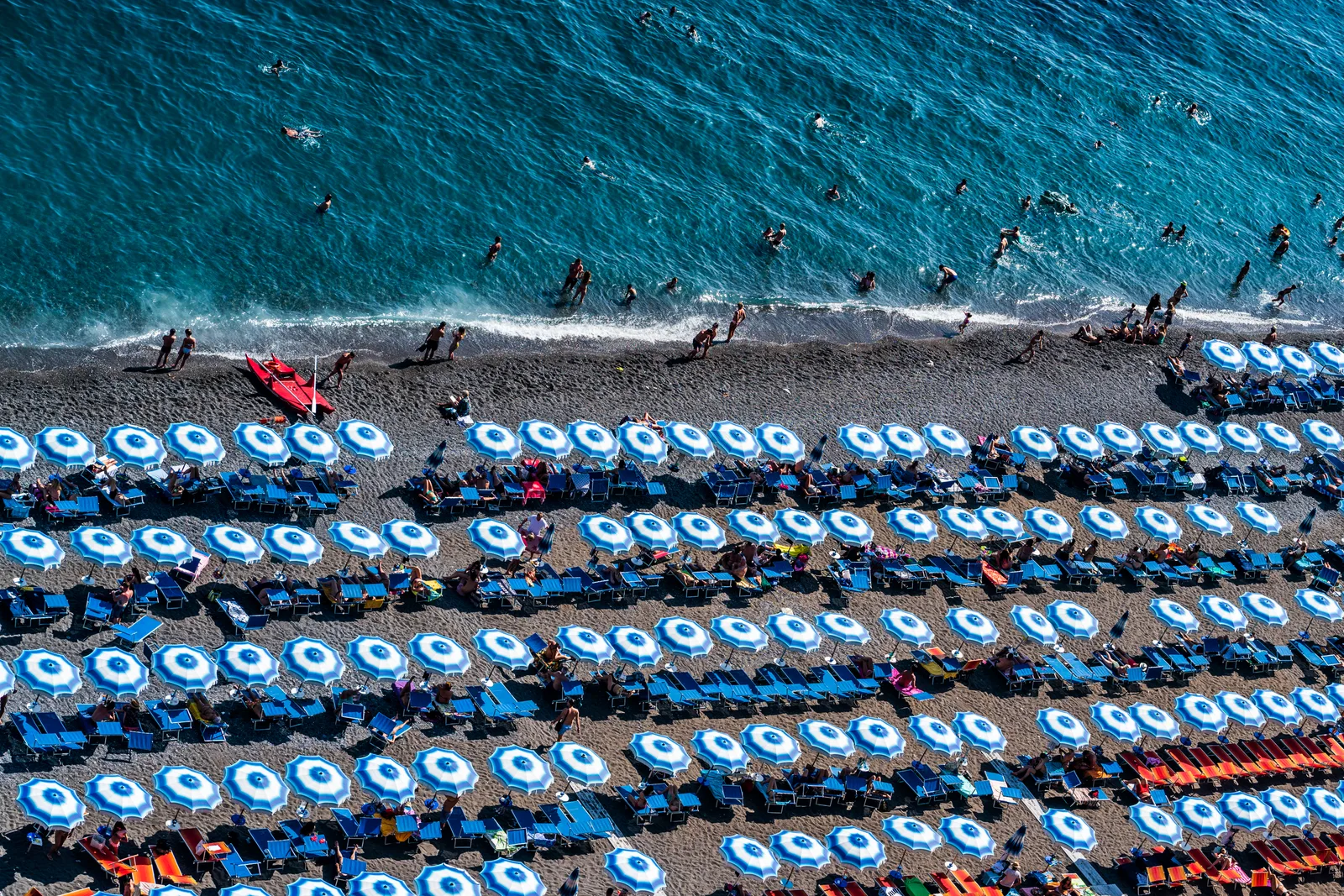 Rows of beach umbrellas on a pebble beach in Positano