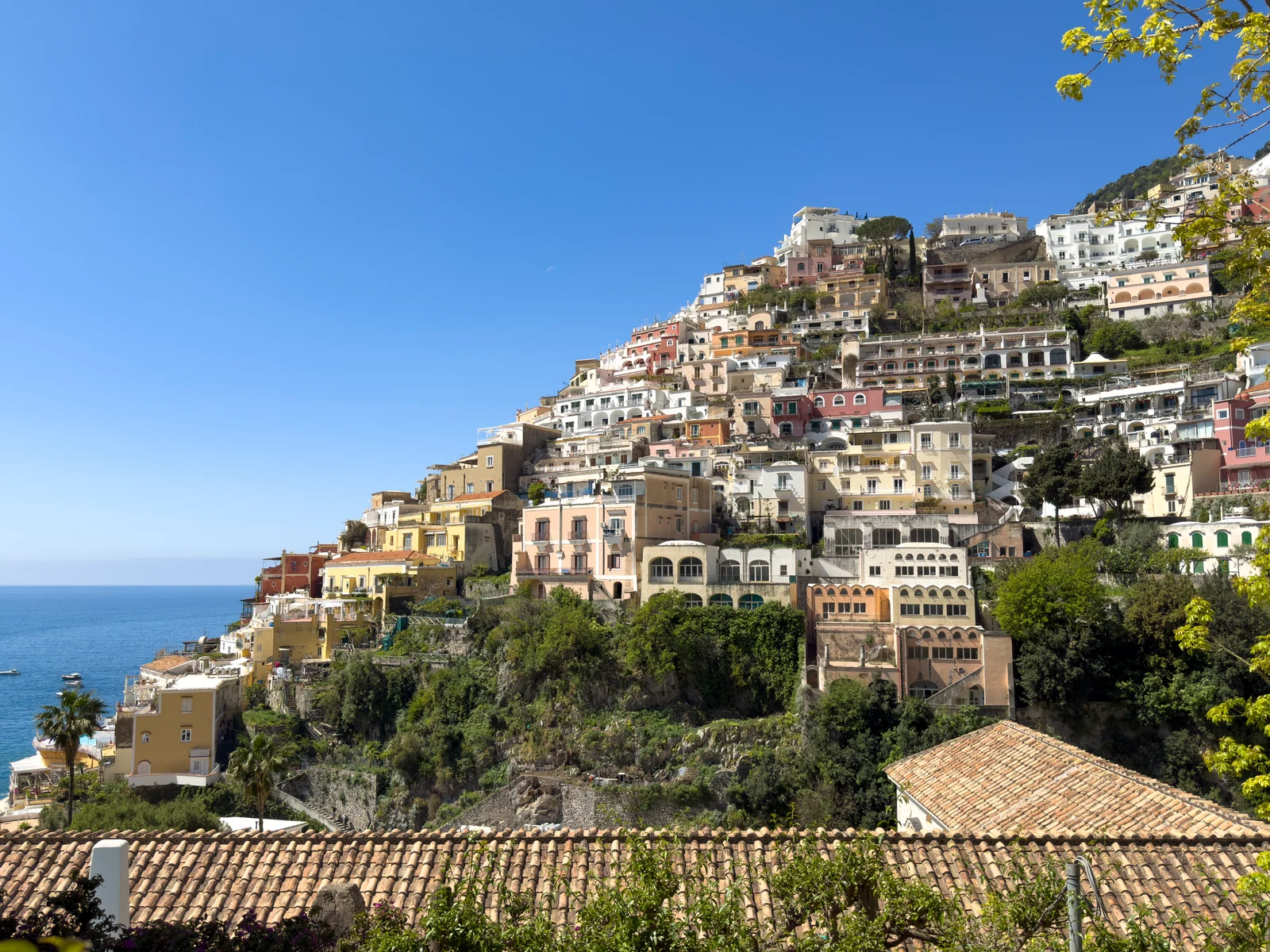 Panoramaudsigt over Positano fra vandet, der viser Spiaggia Grande strand og mole