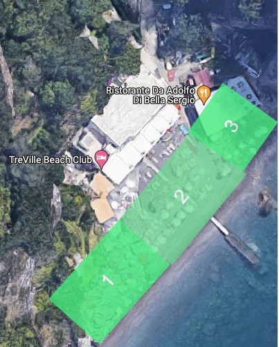 Laurito Beach cove with cliff backdrop and beach clubs along the shoreline