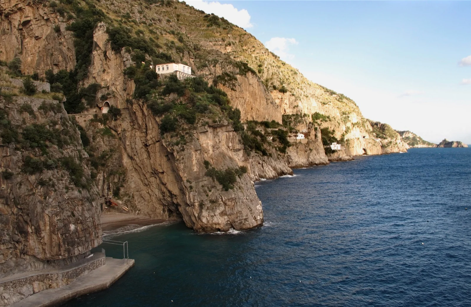 Clear turquoise water at Marina di Praia with swimmers near the pebble shore