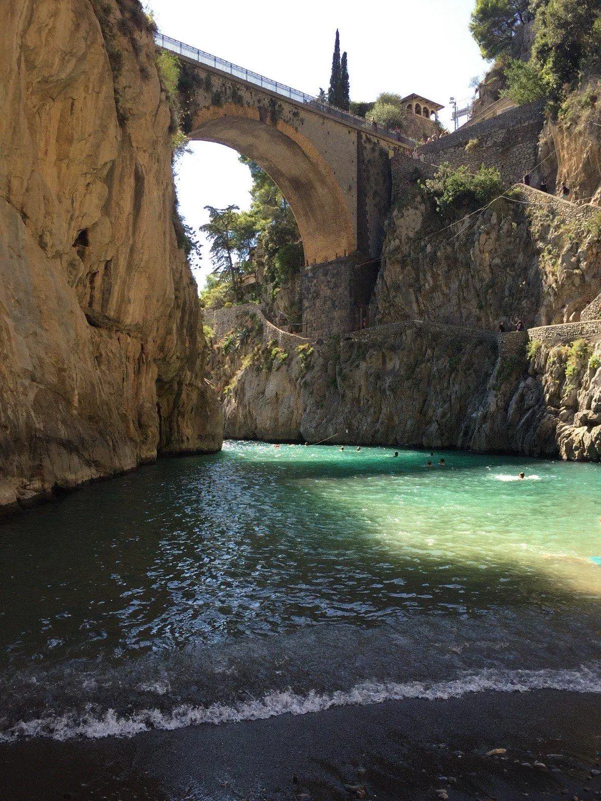 Fiordo di Furore bridge seen from the sea with cliffs framing the narrow inlet