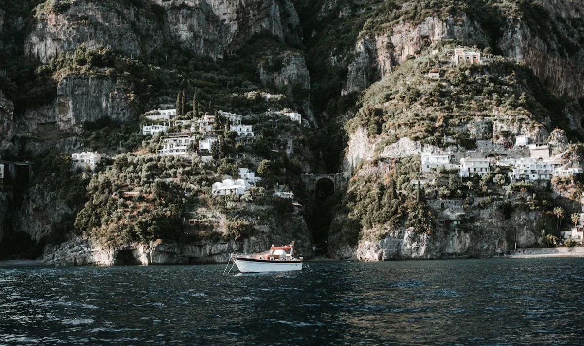 Ferry crossing the Amalfi Coast with clifftop towns in the background