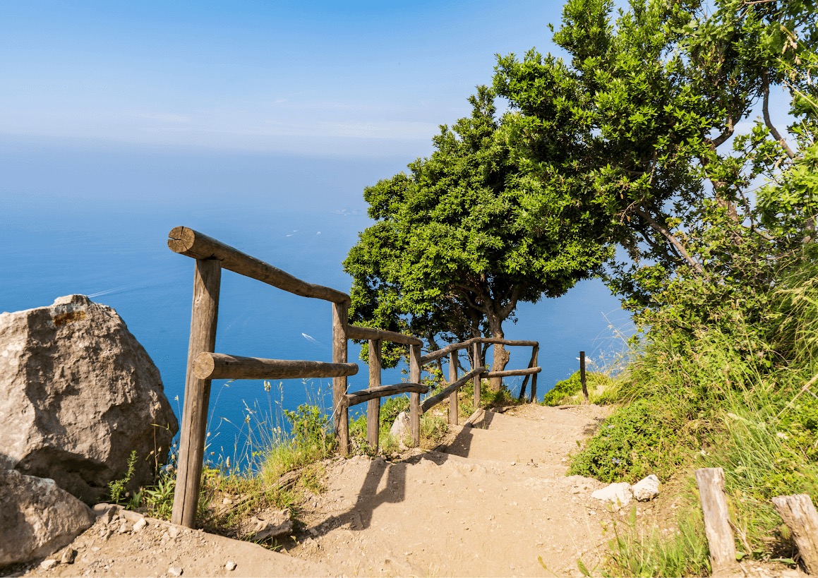 Hikers on the Path of the Gods trail with coastal views